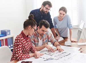 Architekturteam bespricht gemeinsam einen Grundrissplan – Archicad Lizenz für Planungsbüros
